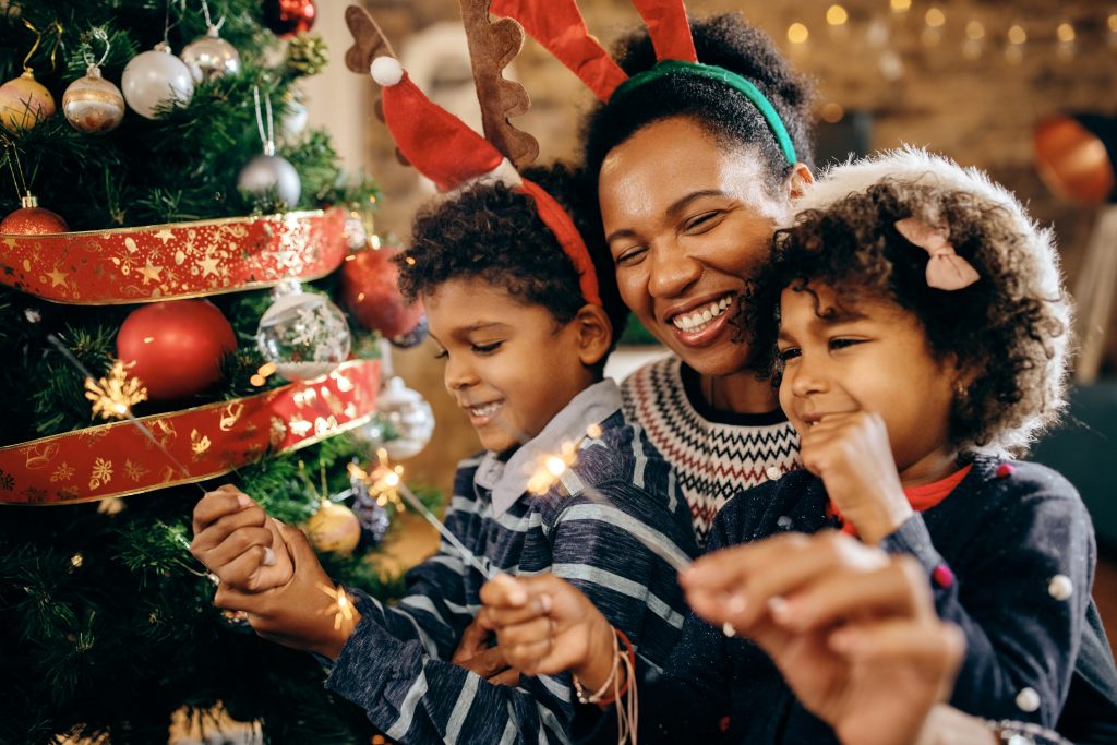 Happy African American family using sparklers while celebrating
